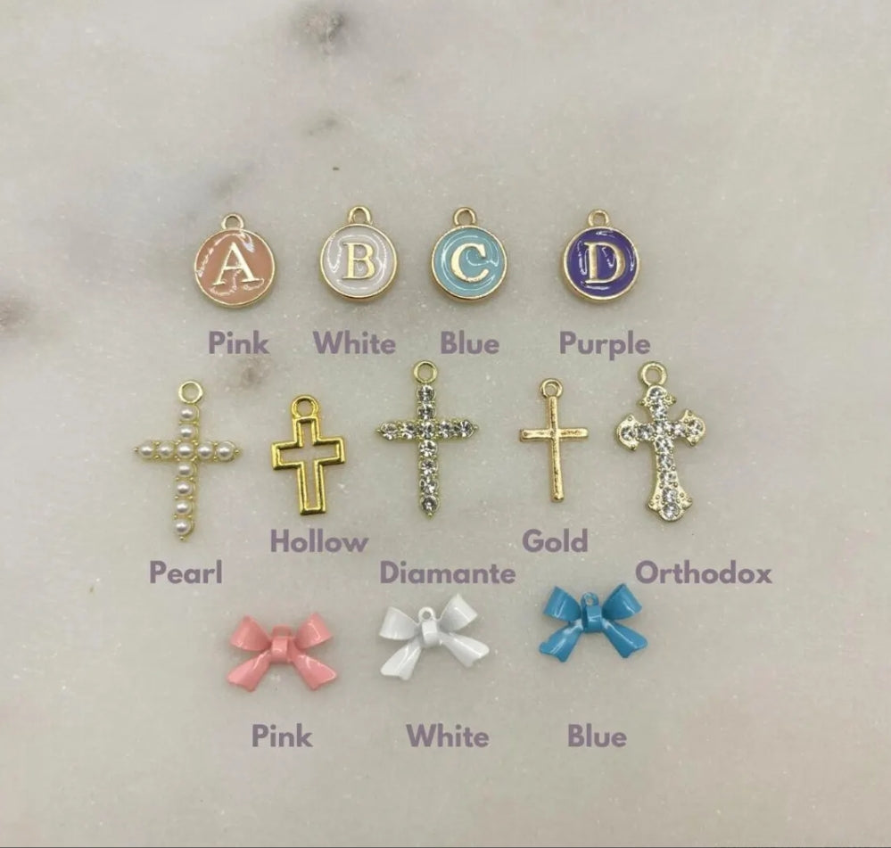 Small gold pin personalised with bow, letter charm and cross