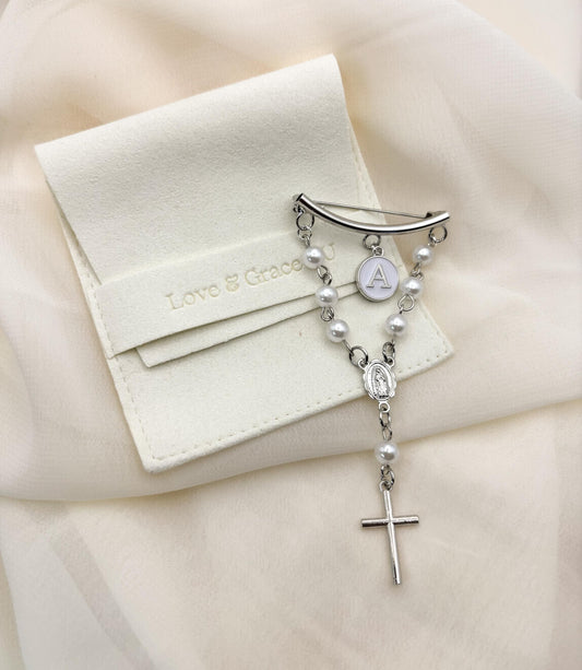 Personalized sterling silver rosary baptism pin for baby girls or boys: curved bar clasp with freshwater pearl chain, custom white letter charm, Our Lady of Guadalupe medal, and dainty silver cross. Packaged in elegant white satin pouch embossed &quot;Love & Grace.&quot; Hypoallergenic christening keepsake, newborn gift idea. Handcrafted Virgin Mary and Religious cross heirloom jewelry.